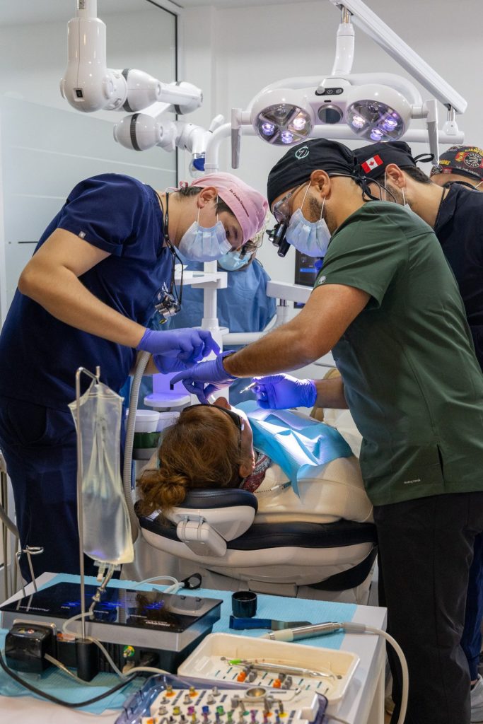 Multiple dentists performing dental work on a patient.