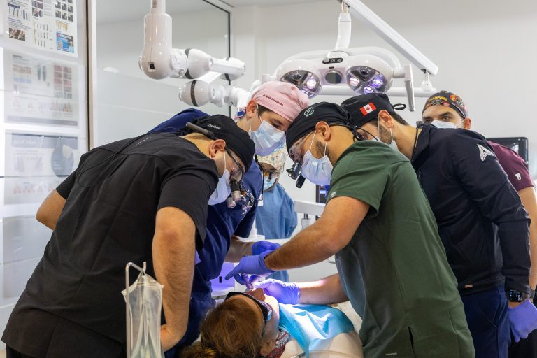 Multiple dentists performing dental work on a patient.