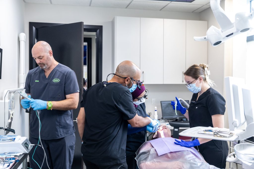 Multiple dentists performing dental work on a patient.