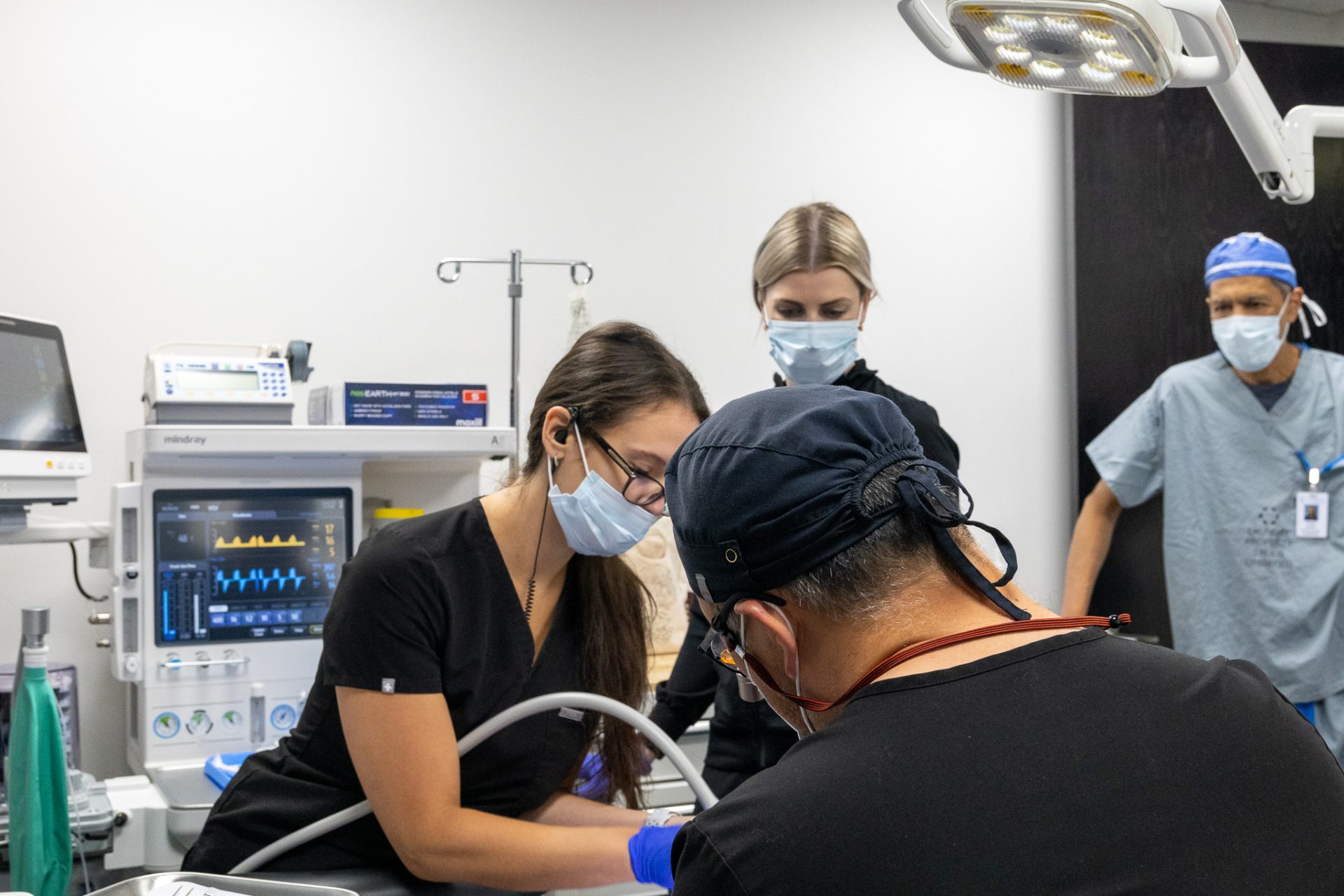 A team of doctors and hygienists performing sedation dentistry on a patient.
