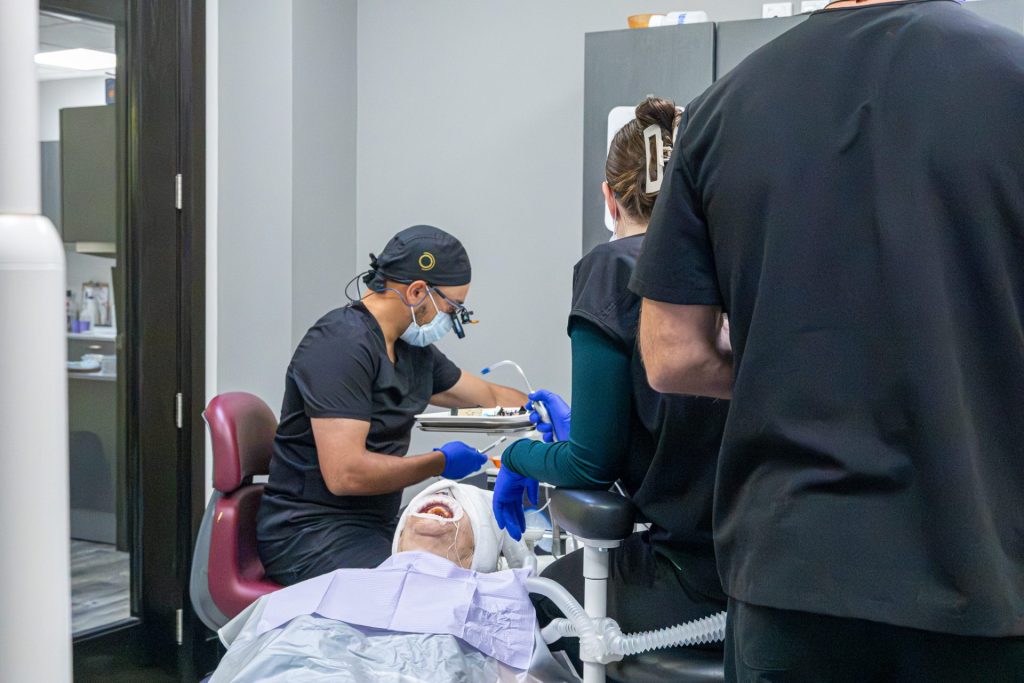 Multiple dentists performing dental work on a patient.
