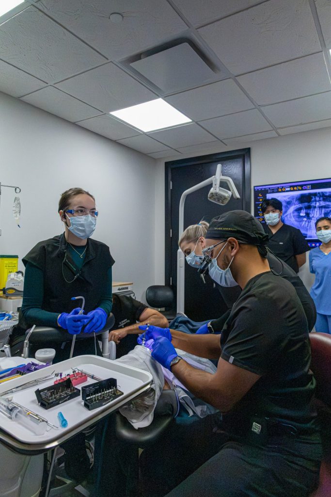 A team of doctors and hygienists performing sedation dentistry on a patient.